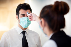 Employee having temperature taken upon entry to job site.