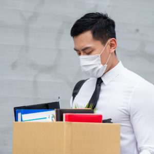employee wearing mask carrying box of belongings